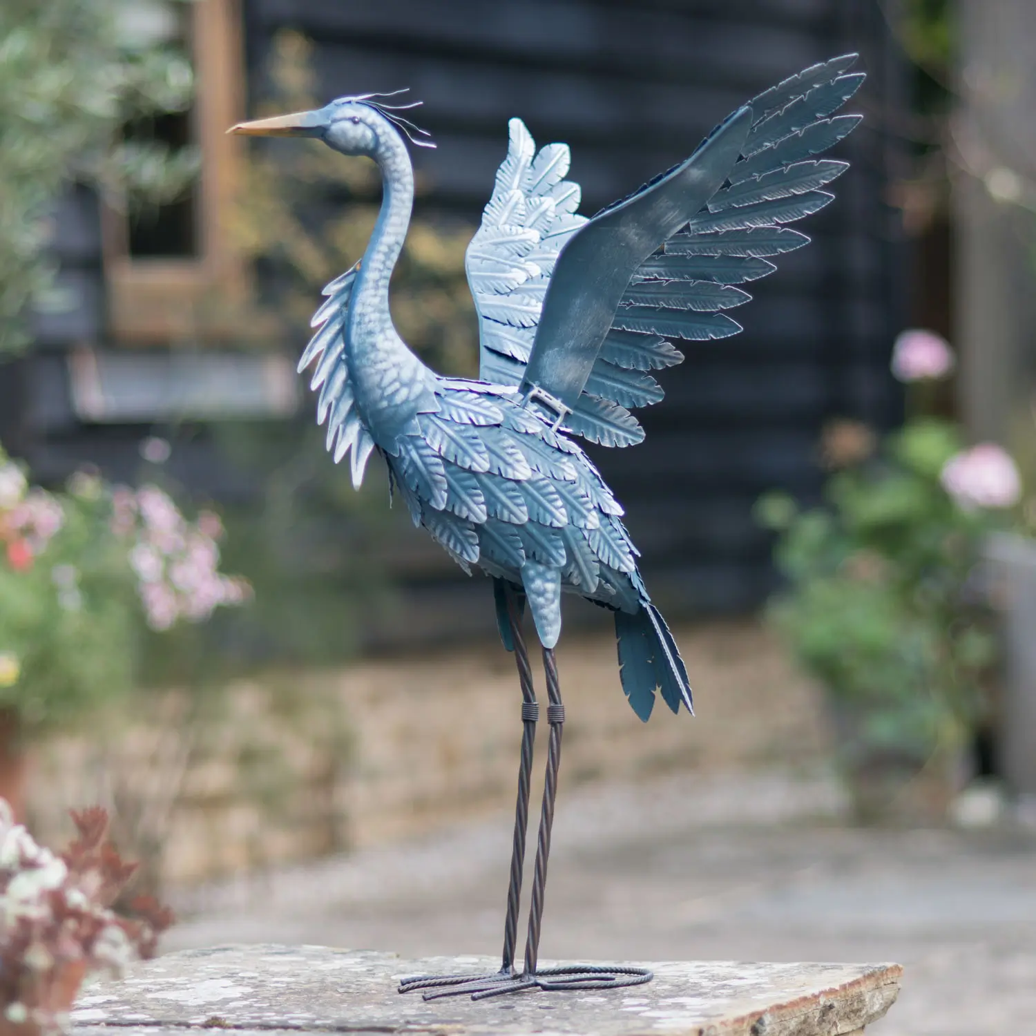 A garden ornament heron photographed in a garden